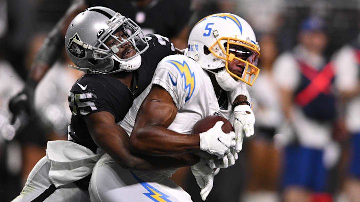 Jan 9, 2022; Paradise, Nevada, USA; Los Angeles Chargers wide receiver Josh Palmer (5) catches a touchdown pass ahead of Las Vegas Raiders tight end Derek Carrier (85) during the second half at Allegiant Stadium.