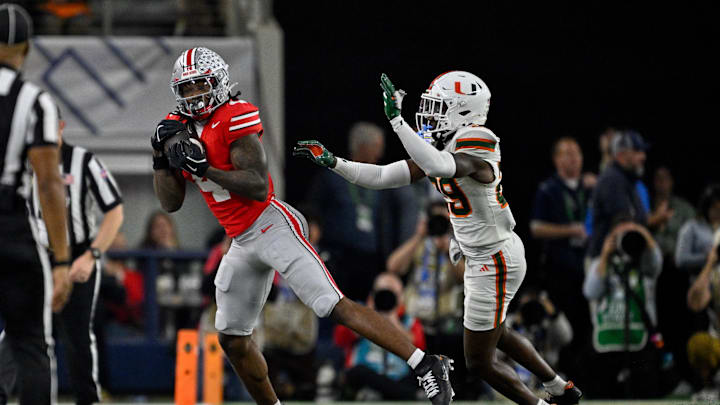 Dec 31, 2025; Arlington, TX, USA; Ohio State Buckeyes wide receiver Jeremiah Smith (4) catches a pass in front of Miami Hurricanes defensive back OJ Frederique Jr. (29) during the 2025 Cotton Bowl and quarterfinal game of the College Football Playoff at AT&T Stadium. Mandatory Credit: Jerome Miron-Imagn Images