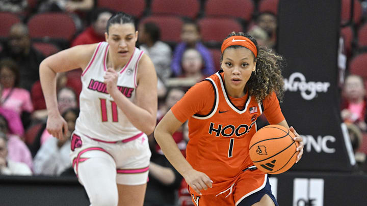 Feb 22, 2026; Louisville, Kentucky, USA;  Virginia Cavaliers guard Paris Clark (1) dribbles against Louisville Cardinals forward Elif Istanbulluoglu (11) during the second half at KFC Yum! Center. Mandatory Credit: Jamie Rhodes-Imagn Images