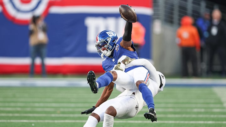 Dec 8, 2024; East Rutherford, New Jersey, USA; New York Giants wide receiver Darius Slayton (86) is tackled by New Orleans Saints cornerback Kool-Aid McKinstry (14) during the second half at MetLife Stadium. Mandatory Credit: Vincent Carchietta-Imagn Images