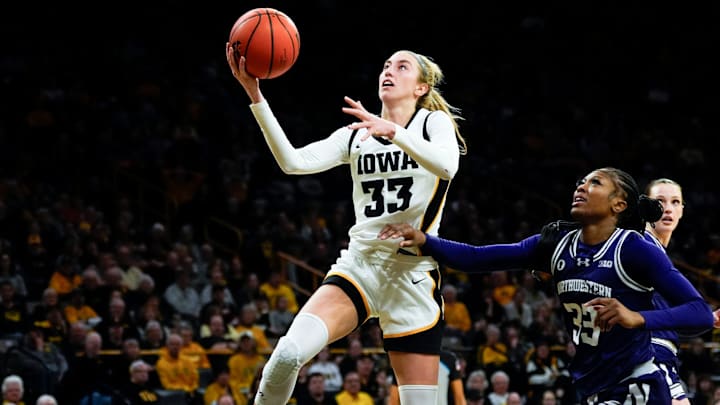 Iowa guard Lucy Olsen (33) shoots a layup defended by Northwestern forward Taylor Williams (33) Tuesday, Jan. 28, 2025 at Carver-Hawkeye Arena in Iowa City, Iowa.