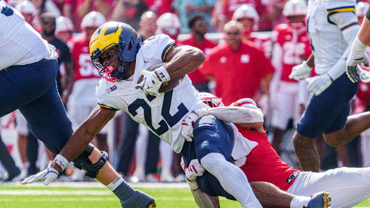 Sep 20, 2025; Lincoln, Nebraska, USA; Michigan Wolverines running back Justice Haynes (22) gets tackled by Nebraska Cornhuskers linebacker Javin Wright (0) during the second quarter at Memorial Stadium. Mandatory Credit: Dylan Widger-Imagn Images