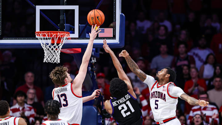 Dec 30, 2024; Tucson, Arizona, USA; TCU Horned Frogs Noah Reynolds (21) makes a layup against Arizona Wildcats forward Henri Veesaar (13) and Arizona Wildcats guard KJ Lewis (5) during the second half of the game at McKale Center. Mandatory Credit: Aryanna Frank-Imagn Images