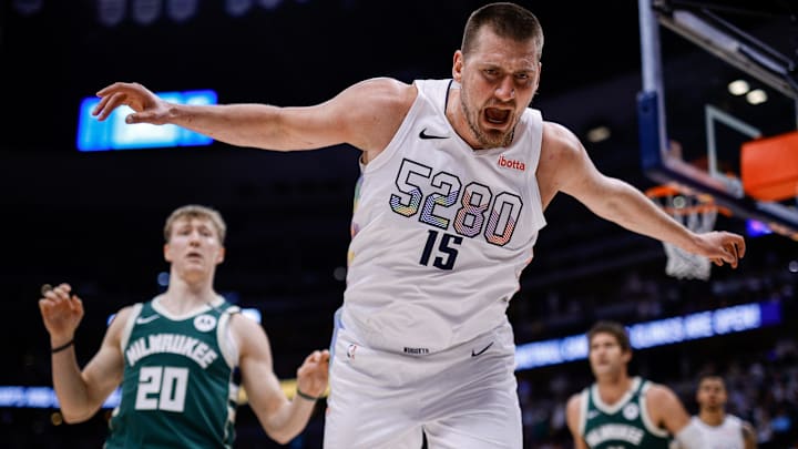 Mar 26, 2025; Denver, Colorado, USA; Denver Nuggets center Nikola Jokic (15) reacts as he goes out of bounds as Milwaukee Bucks guard AJ Green (20) looks on in the first quarter at Ball Arena. Mandatory Credit: Isaiah J. Downing-Imagn Images