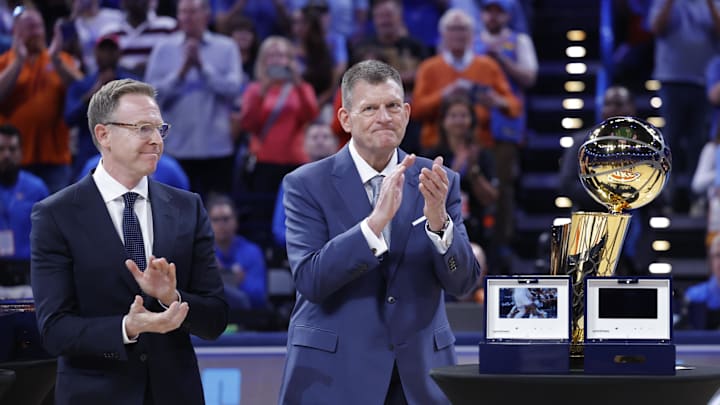 Oct 21, 2025; Oklahoma City, Oklahoma, USA; Oklahoma City Thunder general manager Sam Presti and owner Clay Bennett stand next to the Larry O'Brien Championship Trophy during the ring ceremony before the start of a game against the Houston Rockets at Paycom Center. Mandatory Credit: Alonzo Adams-Imagn Images Oct 21, 2025; Oklahoma City, Oklahoma, USA; Oklahoma City Thunder general manager Sam Presti and owner Clay Bennett stand next to the Larry O'Brien Championship Trophy during the ring ceremony before the start of a game against the Houston Rockets at Paycom Center. Mandatory Credit: Alonzo Adams-Imagn Images