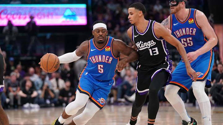 Mar 25, 2025; Sacramento, California, USA; Oklahoma City Thunder guard Luguentz Dort (5) dribbles the ball next to Sacramento Kings forward Keegan Murray (13) in the fourth quarter at the Golden 1 Center. Mandatory Credit: Cary Edmondson-Imagn Images