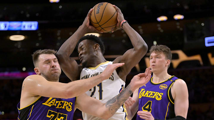 Apr 4, 2025; Los Angeles, California, USA;  Los Angeles Lakers guard Luka Doncic (77) gets an elbow in the face as he is defending New Orleans Pelicans center Yves Missi (21) in the second half at Crypto.com Arena. Mandatory Credit: Jayne Kamin-Oncea-Imagn Images