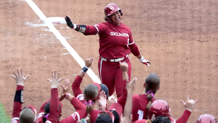 Oklahoma outfielder Ella Parker meets her teammates at the plate after blasting a home run against Georgia.