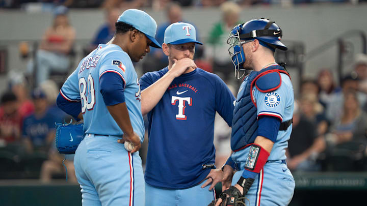 Apr 26, 2026; Arlington, Texas, USA;  Texas Rangers pitcher Kumar Rocker (80) is visited on the mound by pitching coach Jordan Tiegs (83) and catcher Danny Jansen (9) during the fifth inning against the Athletics at Globe Life Field. Mandatory Credit: Raymond Carlin III-Imagn Images