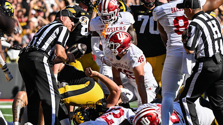 Sep 27, 2025; Iowa City, Iowa, USA; Iowa Hawkeyes quarterback Mark Gronowski (on the ground) scores on a 3 yard touchdown run as Indiana Hoosiers linebacker Isaiah Jones (46) looks on during the second quarter at Kinnick Stadium. Mandatory Credit: Jeffrey Becker-Imagn Images