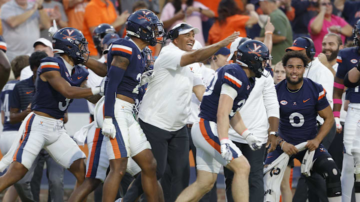 Oct 12, 2024; Charlottesville, Virginia, USA; Virginia Cavaliers head coach Tony Elliott (center) celebrates after Virginia Cavaliers safety Ethan Minter (30) intercepts the ball against the Louisville Cardinals during the second half at Scott Stadium. Mandatory Credit: Amber Searls-Imagn Images Oct 12, 2024; Charlottesville, Virginia, USA; Virginia Cavaliers head coach Tony Elliott (center) celebrates after Virginia Cavaliers safety Ethan Minter (30) intercepts the ball against the Louisville Cardinals during the second half at Scott Stadium. Mandatory Credit: Amber Searls-Imagn Images