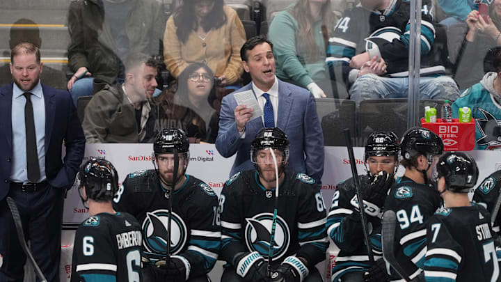 Feb 17, 2024; San Jose, California, USA; San Jose Sharks head coach David Quinn (center) talks to