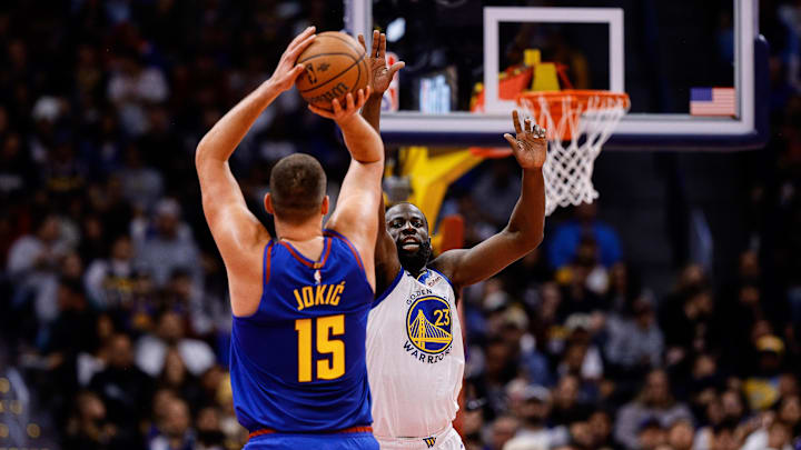 Nov 7, 2025; Denver, Colorado, USA; Denver Nuggets center Nikola Jokic (15) attempts a shot under pressure from Golden State Warriors forward Draymond Green (23) in the second quarter at Ball Arena. Mandatory Credit: Isaiah J. Downing-Imagn Images