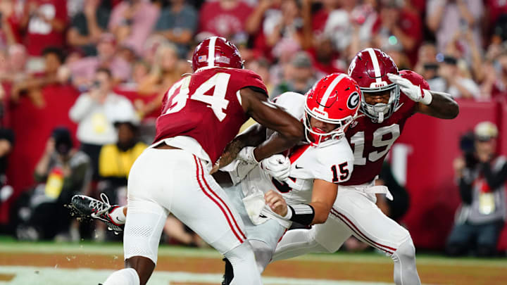 Sep 28, 2024; Tuscaloosa, Alabama, USA;  Georgia Bulldogs quarterback Carson Beck (15) is hit in the end zone by Alabama Crimson Tide linebacker Que Robinson (34) and linebacker Keanu Koht (19) after throwing a pass during the first half at Bryant-Denny Stadium. Mandatory Credit: John David Mercer-Imagn Images