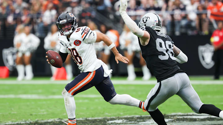 Sep 28, 2025; Paradise, Nevada, USA; Chicago Bears quarterback Caleb Williams (18) looks for an open receiver while being pressured by Las Vegas Raiders defensive end Maxx Crosby (98) in the second quarter at Allegiant Stadium. Mandatory Credit: Kiyoshi Mio-Imagn Images
