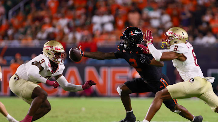 Oct 26, 2024; Miami Gardens, Florida, USA; Miami Hurricanes wide receiver Isaiah Horton (2) attempts but cannot catch the football against Florida State Seminoles defensive back Azareye'h Thomas (8) and linebacker Omar Graham Jr. (9) during the fourth quarter at Hard Rock Stadium. Mandatory Credit: Sam Navarro-Imagn Images