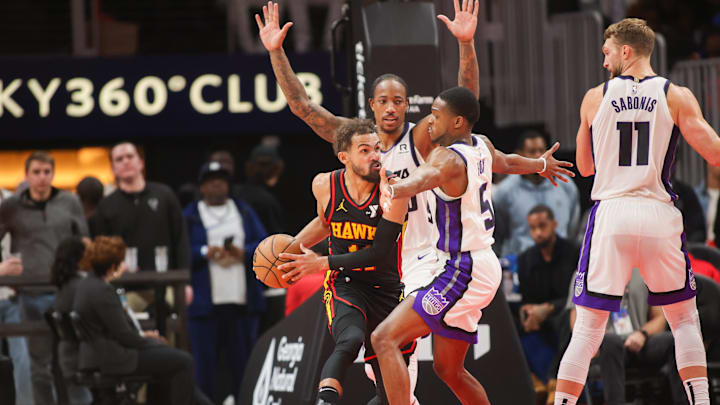 Nov 1, 2024; Atlanta, Georgia, USA; Atlanta Hawks guard Trae Young (11) is defended by Sacramento Kings forward DeMar DeRozan (10) and guard De'Aaron Fox (5) in the second quarter at State Farm Arena. Mandatory Credit: Brett Davis-Imagn Images
