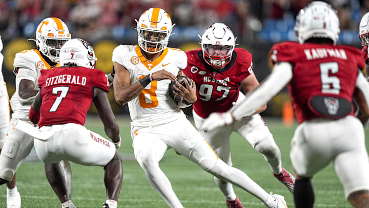 Sep 7, 2024; Charlotte, North Carolina, USA; North Carolina State Wolfpack safety Bishop Fitzgerald (7) looks to tackle Tennessee Volunteers quarterback Nico Iamaleava (8) during the second half at the Dukes Mayo Classic at Bank of America Stadium. Mandatory Credit: Jim Dedmon-Imagn Images