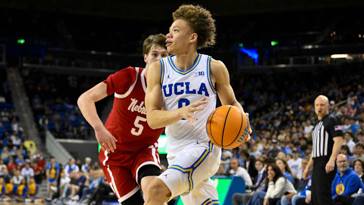 Mar 3, 2026; Los Angeles, California, USA; UCLA Bruins guard Trent Perry (0) drives the baseline past Nebraska Cornhuskers forward Braden Frager (5) during the first half at Pauley Pavilion presented by Wescom Financial. Mandatory Credit: Robert Hanashiro-Imagn Images