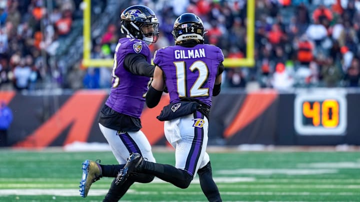 Baltimore Ravens linebacker Kyle van Noy (53) hands an intercepted ball off to safety Alohi Gilman (12) who runs it back Baltimore Ravens linebacker Kyle van Noy (53) hands an intercepted ball off to safety Alohi Gilman (12) who runs it back