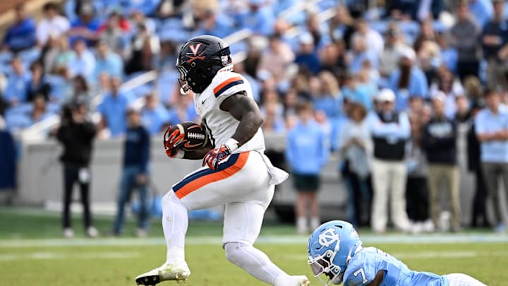 Oct 25, 2025; Chapel Hill, North Carolina, USA; Virginia Cavaliers running back J'Mari Taylor (3) with the ball as North Carolina Tar Heels linebacker Khmori House (7) defends in the fourth quarter at Kenan Stadium. 