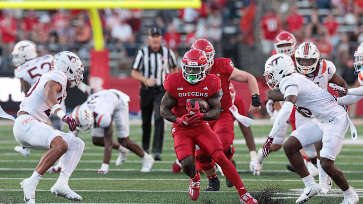 Sep 16, 2023; Piscataway, New Jersey, USA; Rutgers Scarlet Knights running back Kyle Monangai (5) carries the ball as Virginia Tech Hokies safety Caleb Woodson (20) and safety Jaylen Jones (15) pursue  during the second half at SHI Stadium. Mandatory Credit: Vincent Carchietta-Imagn Images
