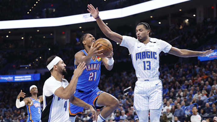 Nov 4, 2024; Oklahoma City, Oklahoma, USA; Oklahoma City Thunder guard Aaron Wiggins (21) shoots between Orlando Magic guard Jalen Suggs (4) and guard Jett Howard (13) during the second half at Paycom Center. Mandatory Credit: Alonzo Adams-Imagn Images