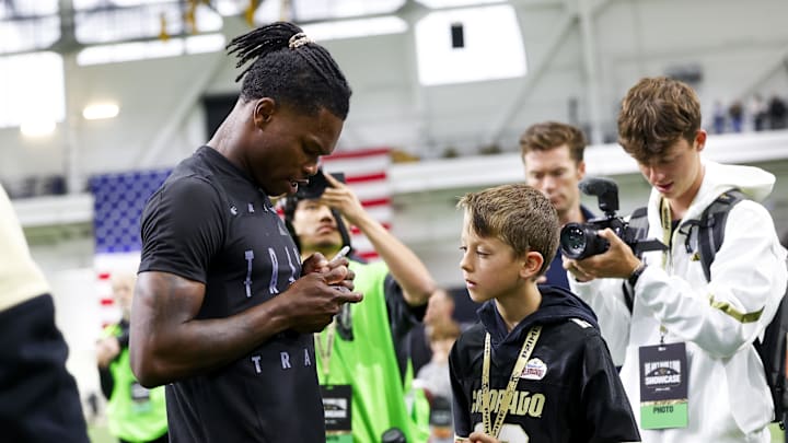 Apr 4, 2025; Boulder, CO, USA; Colorado Buffaloes wide receiver Travis Hunter (12) signs a trading card for a young fan after the University of Colorado NFL Showcase at the CU Indoor Practice Facility. Mandatory Credit: Michael Ciaglo-Imagn Images Apr 4, 2025; Boulder, CO, USA; Colorado Buffaloes wide receiver Travis Hunter (12) signs a trading card for a young fan after the University of Colorado NFL Showcase at the CU Indoor Practice Facility. Mandatory Credit: Michael Ciaglo-Imagn Images