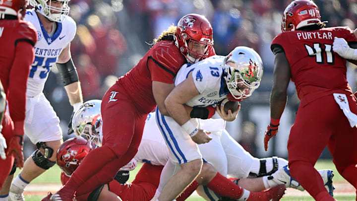 Nov 25, 2023; Louisville, Kentucky, USA; Louisville Cardinals defensive lineman Ashton Gillotte (9) sacks Kentucky Wildcats quarterback Devin Leary (13) during the second half at L&N Federal Credit Union Stadium. Kentucky defeated Louisville 38-31. Mandatory Credit: Jamie Rhodes-Imagn Images Nov 25, 2023; Louisville, Kentucky, USA; Louisville Cardinals defensive lineman Ashton Gillotte (9) sacks Kentucky Wildcats quarterback Devin Leary (13) during the second half at L&N Federal Credit Union Stadium. Kentucky defeated Louisville 38-31. Mandatory Credit: Jamie Rhodes-Imagn Images