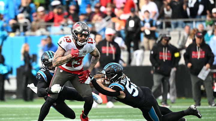 Dec 21, 2025; Charlotte, North Carolina, USA;  Tampa Bay Buccaneers wide receiver Mike Evans (13) with the ball as Carolina Panthers safety Nick Scott (21) and linebacker Christian Rozeboom (56) defend in the fourth quarter at Bank of America Stadium. Mandatory Credit: Bob Donnan-Imagn Images
