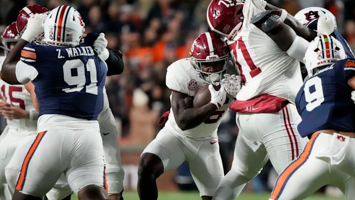 Nov 29, 2025; Auburn, Alabama, USA; Alabama running back Jam Miller (26) tries to push through a hole opened by Alabama offensive lineman Kam Dewberry (71) as he runs the ball against Auburn at Jordan-Hare Stadium. Mandatory Credit: Gary Cosby Jr.-Tuscaloosa News