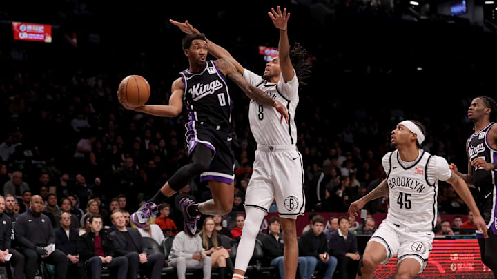 Jan 27, 2025; Brooklyn, New York, USA; Sacramento Kings guard Malik Monk (0) looks to pass the ball against Brooklyn Nets forward Ziaire Williams (8) and guard Keon Johnson (45) during the third quarter at Barclays Center. Mandatory Credit: Brad Penner-Imagn Images
