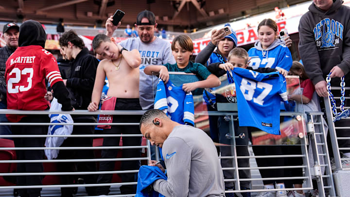 Detroit Lions wide receiver Amon-Ra St. Brown (14) signs autographs for fans.