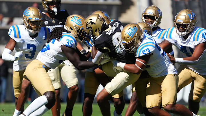 Sep 24, 2022; Boulder, Colorado, USA; UCLA Bruins linebacker Carl Jones Jr. (35) and linebacker Darius Muasau (53) tackle Colorado Buffaloes wide receiver Ty Robinson (80) in the third quarter at Folsom Field. Mandatory Credit: Ron Chenoy-Imagn Images