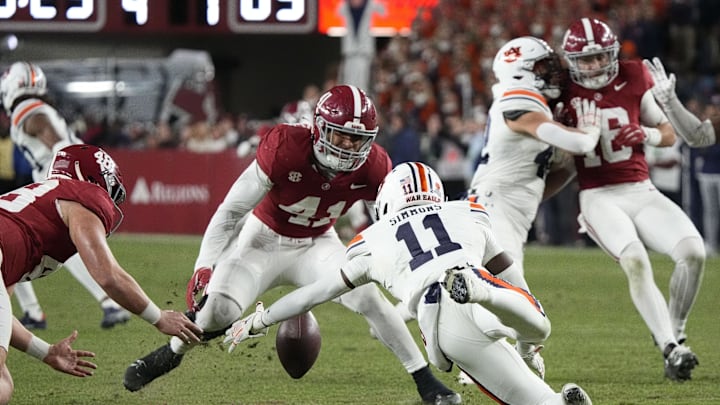 Nov 30, 2024; Tuscaloosa, Alabama, USA;  Auburn Tigers wide receiver Malcolm Simmons (11) fumbles a punt but recovers as Alabama Crimson Tide defensive back Prince Butler (48) and linebacker Justin Okoronkwo (41) close in during second half at Bryant-Denny Stadium. Alabama won 28-14. Mandatory Credit: Gary Cosby Jr.-Imagn Images