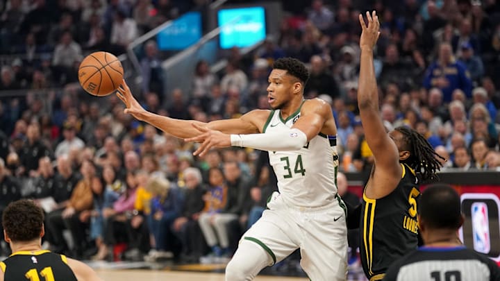 Mar 6, 2024; San Francisco, California, USA; Milwaukee Bucks forward Giannis Antetokounmpo (34) passes the ball away from the reach of Golden State Warriors forward Kevon Looney (5) in the first quarter at the Chase Center. Mandatory Credit: Cary Edmondson-Imagn Images