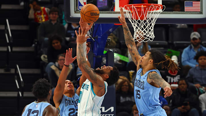 Jan 22, 2025; Memphis, Tennessee, USA; Charlotte Hornets forward Miles Bridges (0) shoots as Memphis Grizzlies guard Desmond Bane (22) and forward Brandon Clarke (15) defends during the third quarter at FedExForum. Mandatory Credit: Petre Thomas-Imagn Images