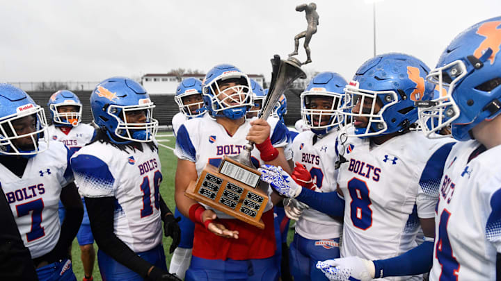 Members of the Millville High School football team celebrate with the newly named Tony Surace/John Pierantozzi Victory Cup after Millville defeated Vineland, 42-7, in the rivalry Thanksgiving Day football game played in Vineland on Thursday, November 28, 2024.
