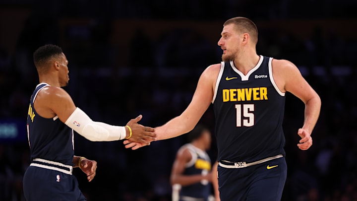 Nov 23, 2024; Los Angeles, California, USA; Denver Nuggets center Nikola Jokic (15) embraces guard Russell Westbrook (4) during the third quarter against the Los Angeles Lakers at Crypto.com Arena. 