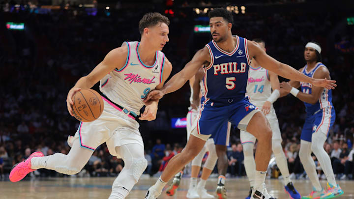 Apr 7, 2025; Miami, Florida, USA; Miami Heat guard Pelle Larsson (9) drives to the basketball as Philadelphia 76ers guard Quentin Grimes (5) defends during the second quarter at Kaseya Center. Mandatory Credit: Sam Navarro-Imagn Images