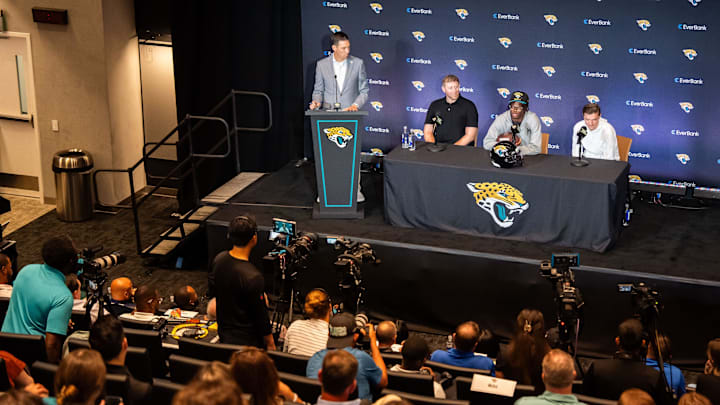 John Dever, Senior Vice President and Chief Communications Officer for the Jacksonville Jaguars, left, claps after introducing the Jacksonville Jaguars’ first-round pick, Colorado Buffaloes wide receiver and defensive back Travis Hunter, third from left, before answering questions during a press conference Friday, March 25, 2025 at Miller Electric Center in Jacksonville, Fla. with Head Coach Liam Coen, second from left and General Manager James Gladstone, right. [Doug Engle/Florida Times-Union]