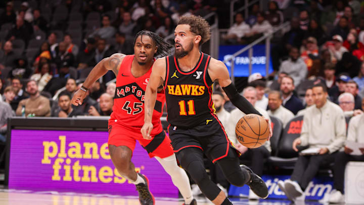Jan 23, 2025; Atlanta, Georgia, USA; Atlanta Hawks guard Trae Young (11) drives past Toronto Raptors guard Davion Mitchell (45) in the second quarter at State Farm Arena. Mandatory Credit: Brett Davis-Imagn Images