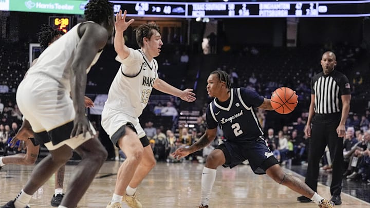 Dec 17, 2025; Winston-Salem, North Carolina, USA;  Longwood Lancers guard Redd Thompson Jr. (2) handles the ball against Wake Forest Demon Deacons forward Cooper Schwieger (13) during the second half at Lawrence Joel Veterans Memorial Coliseum. Mandatory Credit: Jim Dedmon-Imagn Images