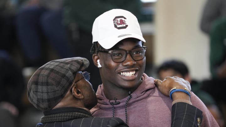 Feb 1, 2023; Washington, D.C., USA; USA  Top prep football player, Nyckoles Harbor of Archbishop Carroll High School in Washington, D.C., gets a hug from his father Azuka Harbor, after Nyckoles committed to South Carolina live on ESPN and signs his Letter of Intent on National Signing Day, Feb. 1, 2023, in the school's gym at Archbishop Carroll High School. Mandatory Credit: Jack Gruber-USA TODAY