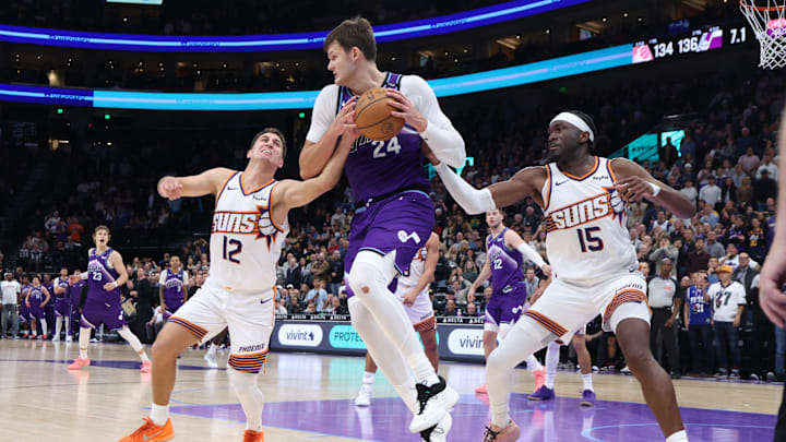 Oct 27, 2025; Salt Lake City, Utah, USA;  Utah Jazz center Walker Kessler (24) rebounds against Phoenix Suns guard Collin Gillespie (12) and center Mark Williams (15) during overtime at Delta Center. Mandatory Credit: Rob Gray-Imagn Images