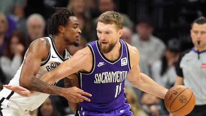 Nov 24, 2024; Sacramento, California, USA; Sacramento Kings forward Domantas Sabonis (11) dribbles against Brooklyn Nets center Nic Claxton (left) during the second quarter at Golden 1 Center. Mandatory Credit: Darren Yamashita-Imagn Images