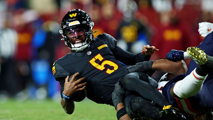 Oct 27, 2024; Landover, Maryland, USA; Washington Commanders quarterback Jayden Daniels (5) reaches for a first down but is short during the fourth quarter against the Chicago Bears at Commanders Field. Mandatory Credit: Peter Casey-Imagn Images