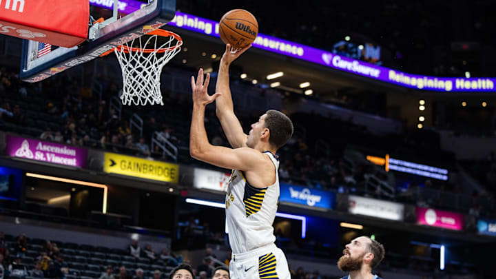 Oct 14, 2024; Indianapolis, Indiana, USA; Indiana Pacers forward Cole Swider (21) shoots the ball while Memphis Grizzlies center Jay Huff (30) defends in the second half at Gainbridge Fieldhouse. Mandatory Credit: Trevor Ruszkowski-Imagn Images