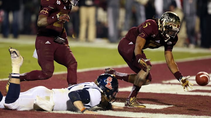 Nov 28, 2013; Starkville, MS, USA; Mississippi Rebels quarterback Bo Wallace (14) dives for the loose ball in the end zone as Mississippi State Bulldogs defensive back Jamerson Love (5) reaches for the fumble during overtime at Davis Wade Stadium. Mississippi State Bulldogs defeat the Mississippi Rebels with a score of 17-10 in overtime.  Mandatory Credit: Spruce Derden-Imagn Images