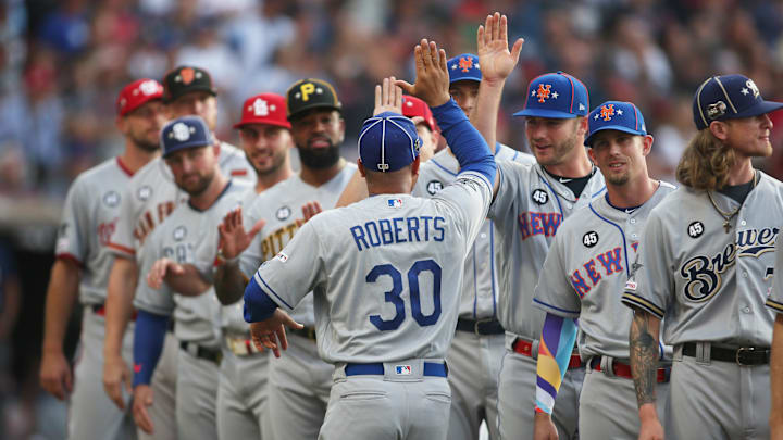 National League manager Dave Roberts (30) of the Los Angeles Dodgers high-fives his team during player introductions before the 2019 MLB All Star Game at Progressive Field on July 9, 2019.